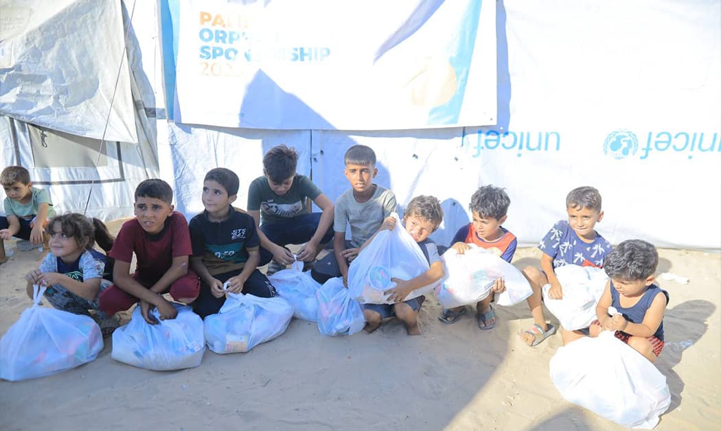 Children in Gaza receiving aid packages from Watan USA
